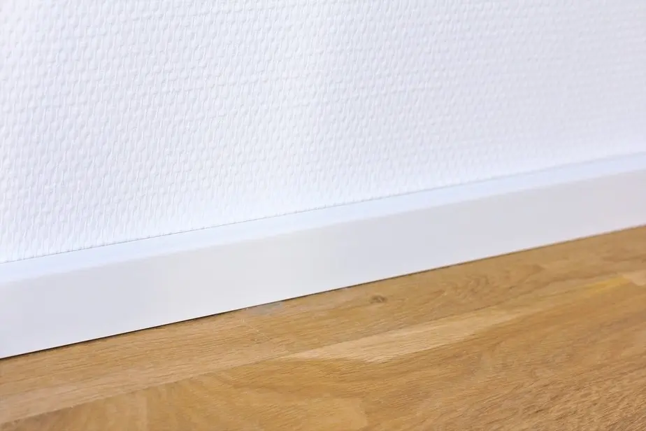 Widok na ścianie listwy przypodłogowej 16 x 40 x 2400 mm drewno lite biały lakierowane kubiczna R3 wpust na klips aranżacja