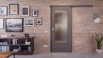 Front-Milieuansicht der vor der Wand laufenden Huga Schiebetür Hygge grau RAL 7037 Duradecor Basic mit Lichtausschnitt LA-DIN