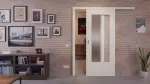 Zweites Milieubild mit vor der Wand laufendem System von Lärche lasiert DIN-LA Basic Durat Schiebetür - Huga