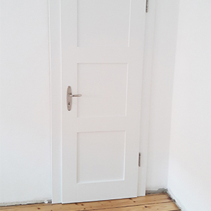 Kundenfoto einer eingebauten weißen Massivholztür mit drei Füllungen