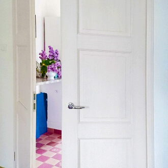 Kundenfoto einer eingebauten eleganten Massivholztür-Doppelflügeltür in astarmer Fichte mit weiß pigmentiert lackiert