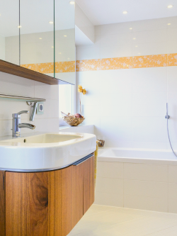 jasna listwa ozdobna wokół lustra łazienkowego między białymi płytkami ściennymi